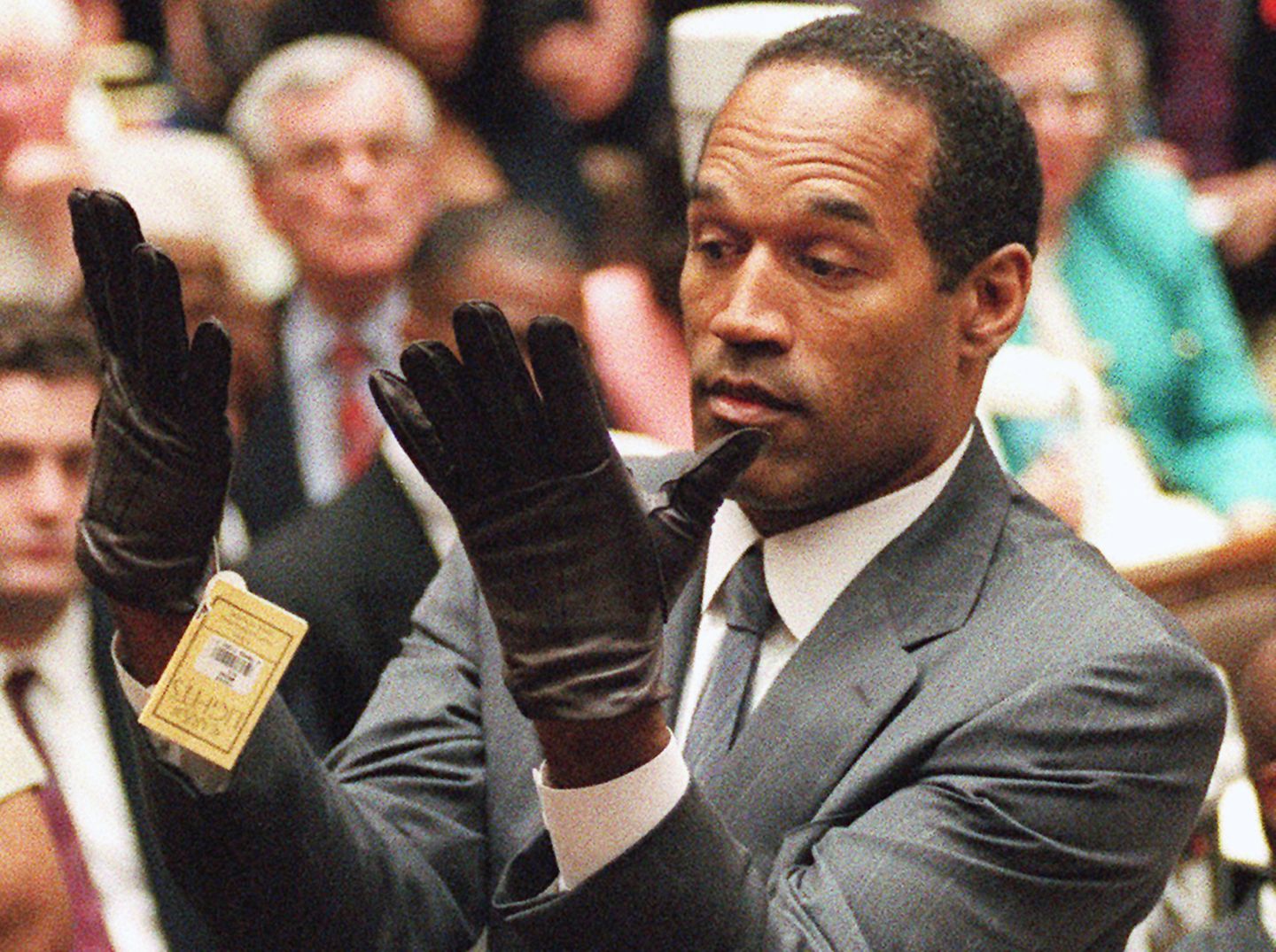 O. J. Simpson schaut verwundert auf zwei schwarze Handschuhe