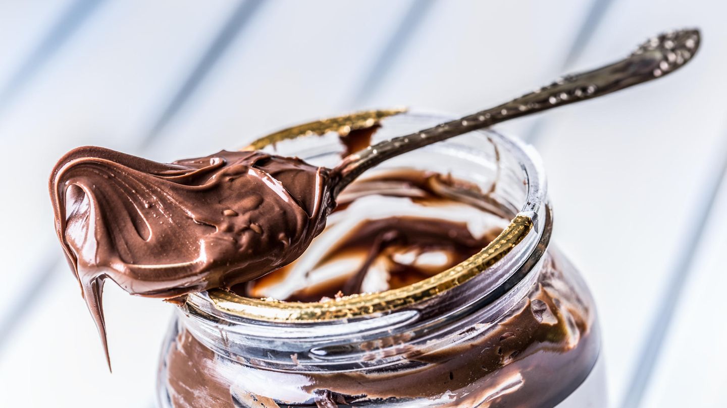 Palmöl ungesund: Ein Löffel mit Nuss-Nougat-Creme liegt auf einem Glas