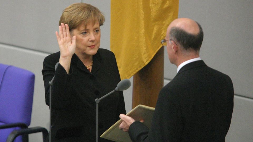 Erster Amtseid: Merkel endet mit "So wahr mir Gott helfe". Bundestagspräsident Norbert Lammert hält das Grundgesetz