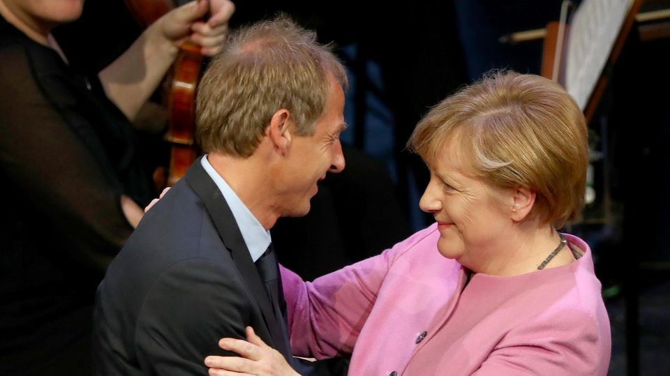 VOE STERN 32/2019 ERFURT, GERMANY - NOVEMBER 03: The former head coach of the German National, current head coach of the US Soccer National Team and new DFB honorary team captain Juergen Klinsmann (L) and Chancellor of Germany Angela Merkel (R) embrace... Fan-Gemeinschaft: Merkel mit Ex- Bundestrainer Jürgen Klinsmann, der sie gern als US-Präsidentin sähe