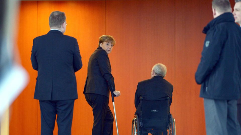 Merkels Stützen: Die Kanzlerin auf Krücken mit ihrem wichtigsten Mann, Finanzminister Wolfgang Schäuble