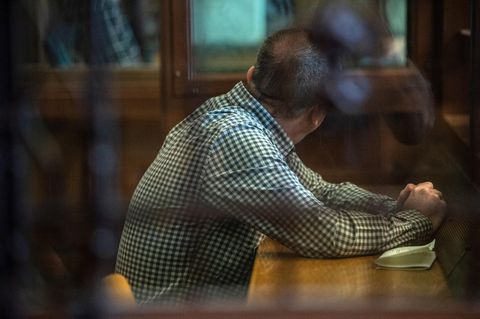 Der Angeklagte sitzt vor Beginn der Verhandlung in einem Gerichtssaal