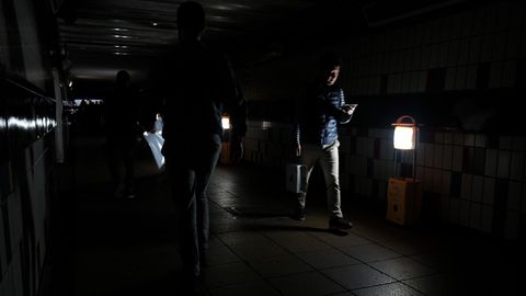 Passagiere gehen bei Stromausfall durch den notbeleuchteten Bahnhof Clapham Junction