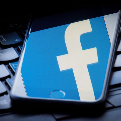 Das Facebook-Logo wird auf einem Smartphone gespiegelt