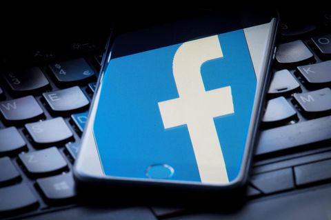 Das Facebook-Logo wird auf einem Smartphone gespiegelt