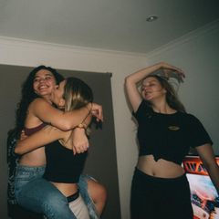 Freundinnen tanzen im Wohnzimmer