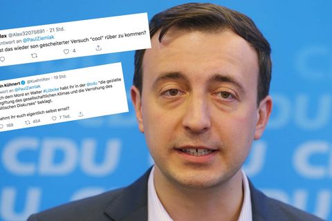 Ein Mann mit braunem Seitenscheitel steht in Hemd und Jackett vor einer blauen Wand mit CDU-Logos. Er spricht in vier Mikrofone
