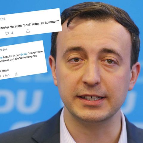 Ein Mann mit braunem Seitenscheitel steht in Hemd und Jackett vor einer blauen Wand mit CDU-Logos. Er spricht in vier Mikrofone