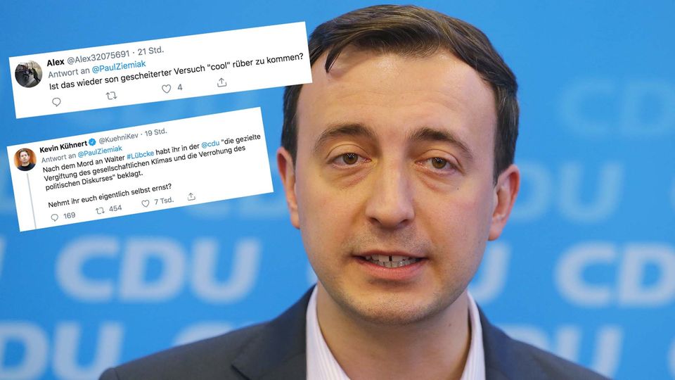 Paul Ziemiak Ein Mann mit braunem Seitenscheitel steht in Hemd und Jackett vor einer blauen Wand mit CDU-Logos. Er spricht in vier Mikrofone