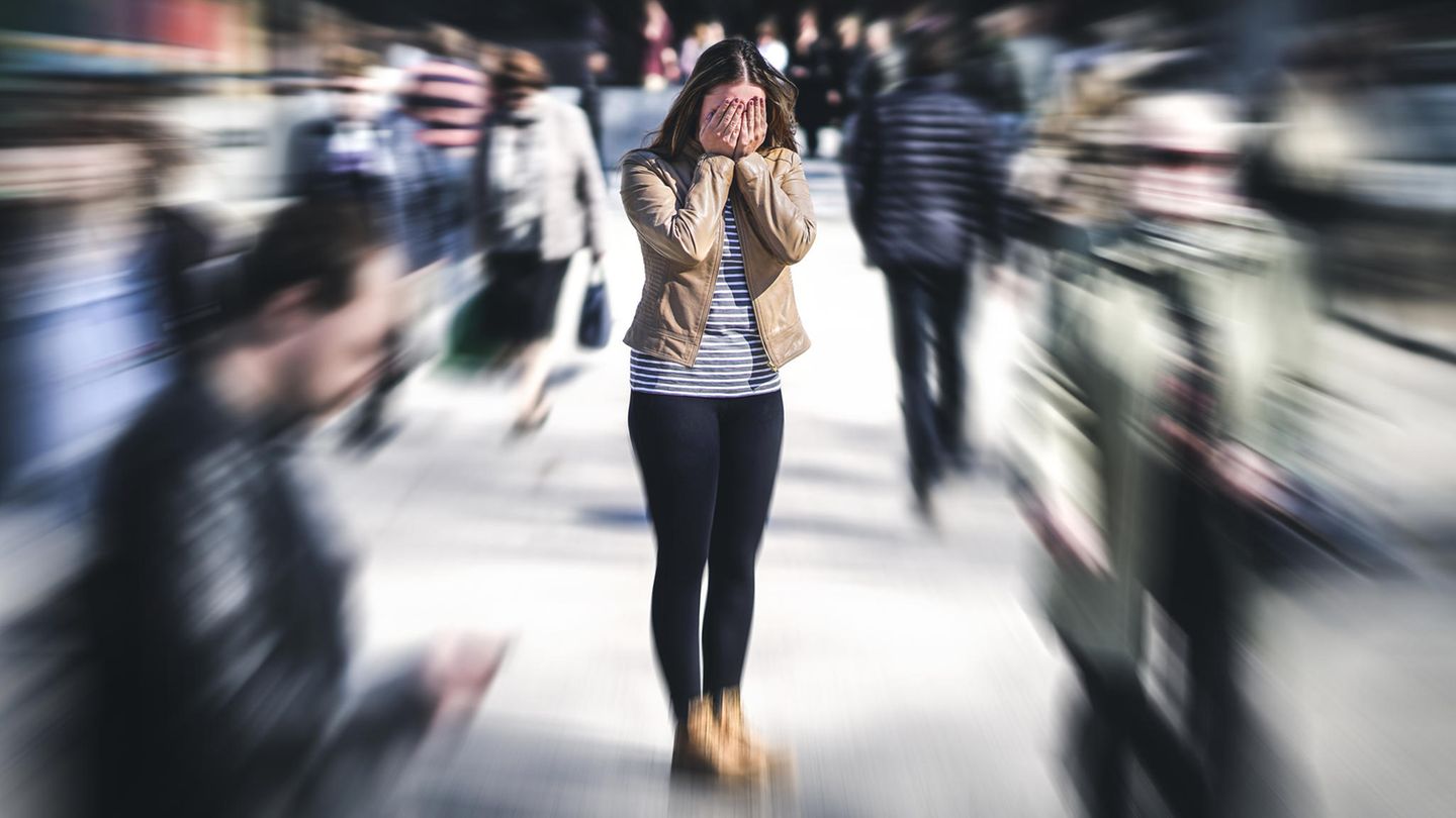 Stress und Krebsrisiko: Eine Frau steht in der Stadt und schlägt sich die Hände vor das Gesicht