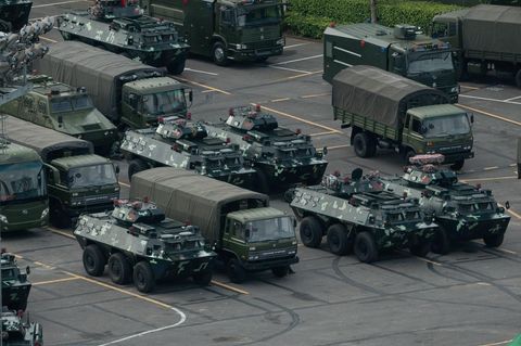 Militärfahrzeuge stehen vor dem Stadion von Shenzhen: China schickt eine eindeutige Botschaft an die Protestbewegung in Hongkong