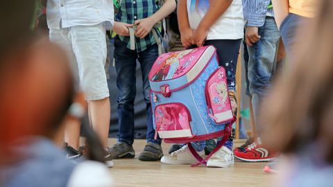 Kinder mit Schulranzen stehen beisammen