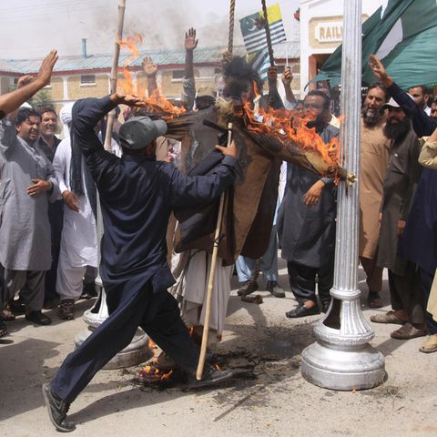Ein Mann schlägt in der pakistanischen Stadt Quetta, auf ein brennendes Bild des indischen Premierministers Modi ein