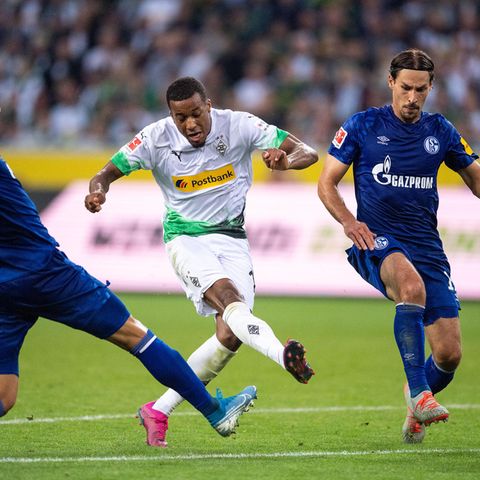 Gladbachs Alassane Plea (m.) schießt aufs Tor. Links läuft Schalkes Matija Nastasic und rechts Benjamin Stambouli