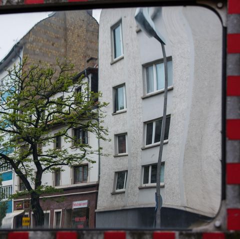 In einem Verkehrsspiegel spiegelt sich eine Häuserzeile
