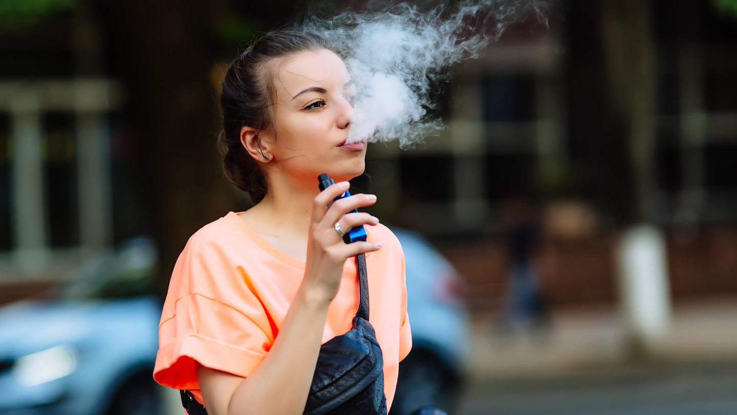 E-Zigarette: Eine junge Frau zieht an einer E-Zigarette