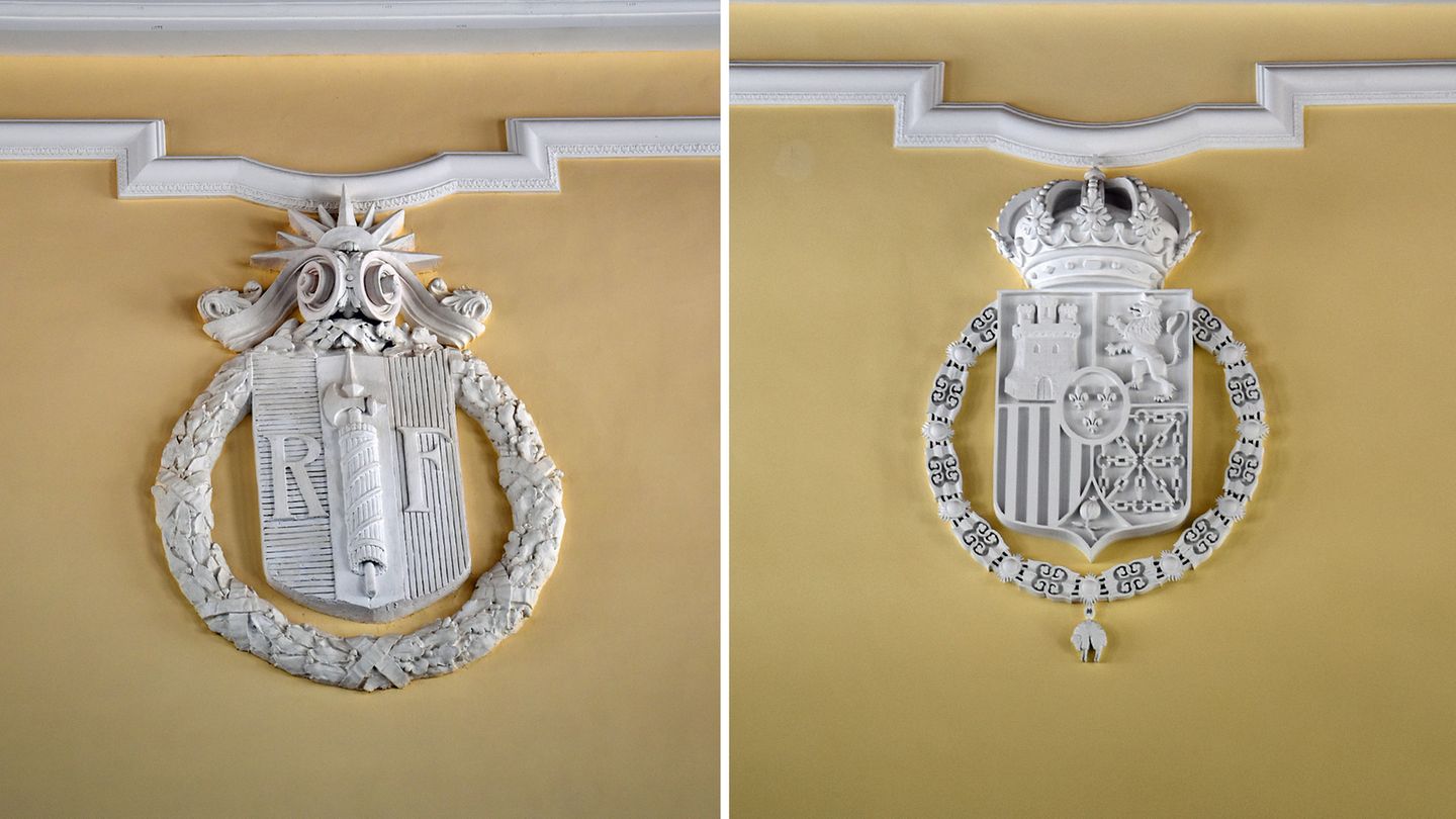 Hoch oben an den Stirnseiten der Lobby prangen die Wappen beider Länder: das Hoheitszeichen der République française, der dritten französischen Republik (links), und das Wappen Spaniens mit Königskrone und Bourbon im Herzschild (rechts).