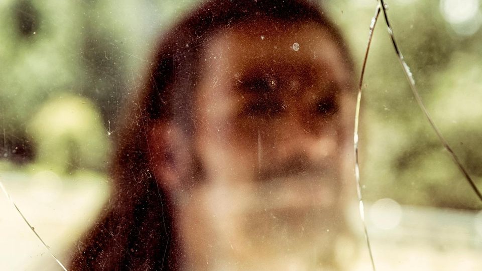 Donovan Allen, fotografiert durch eine gesplitterte Glasscheibe