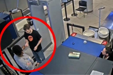 Eine Kameraaufnahme zeigt eine Mitarbeiterin und einen Passagier bei der Securitykontrolle am Flughafen