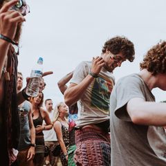 Drei Männer tanzen auf einem Festival