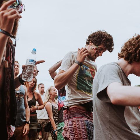 Drei Männer tanzen auf einem Festival