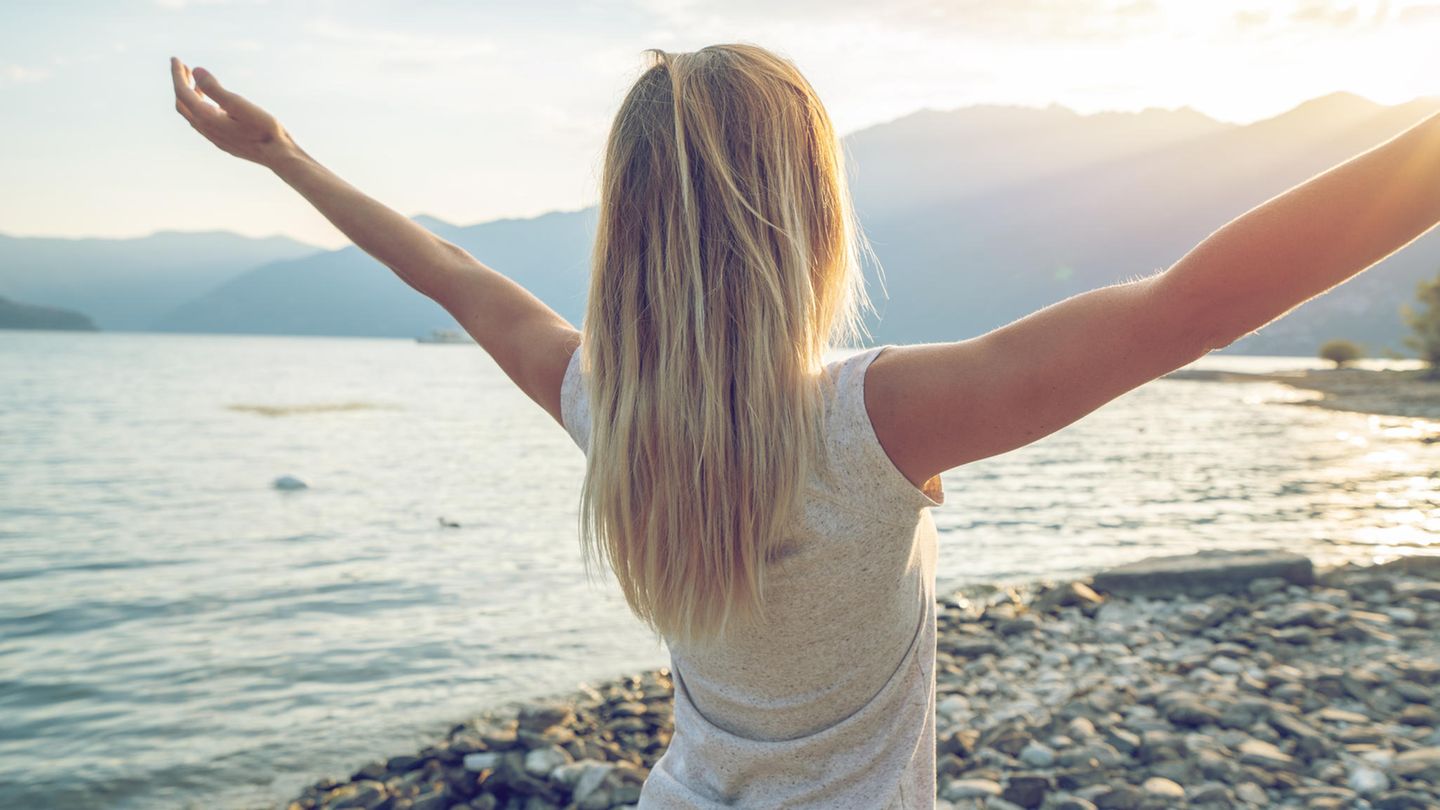 Frau dreht sich Richtung Sonne Frau dreht sich Richtung Sonne