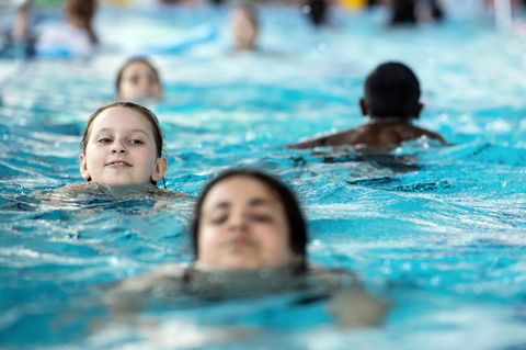 Schulkinder schwimmen im Becken