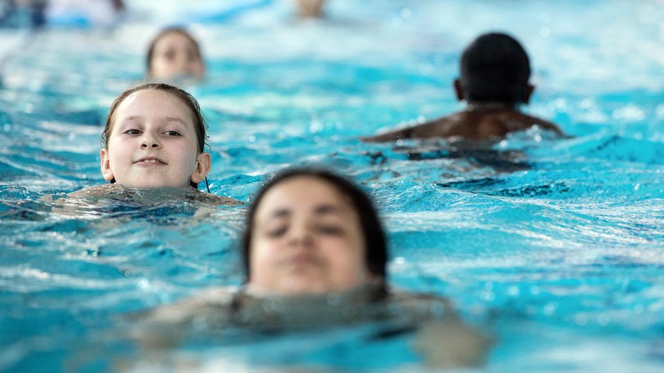 Schulkinder schwimmen im Becken