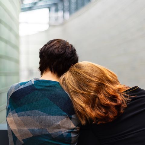 Frau lehnt sich an Schulter einer anderen Frau ab.