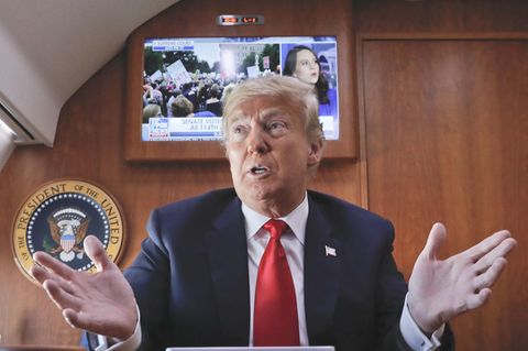 Donald Trump vor laufendem Fernseher in der Präsidentenmaschine Air Force One