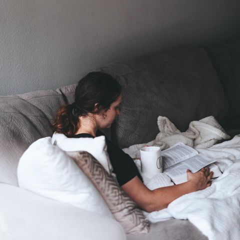 Frau mit Teetasse auf dem Sofa
