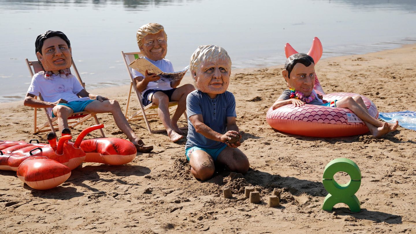 Schon im Vorfeld gab es in dem Badeort zahlreiche Protestaktionen, wie diese Oxfam-Aktivisten, die die Masken mit den Gesichtern von Trudeau, Trump, Johnson und Macron tragen.