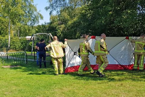  Assen, Niederlande: Rettungskräfte platzieren einen Bildschirm auf einem Spielplatz, auf dem ein Mann getötet wurde