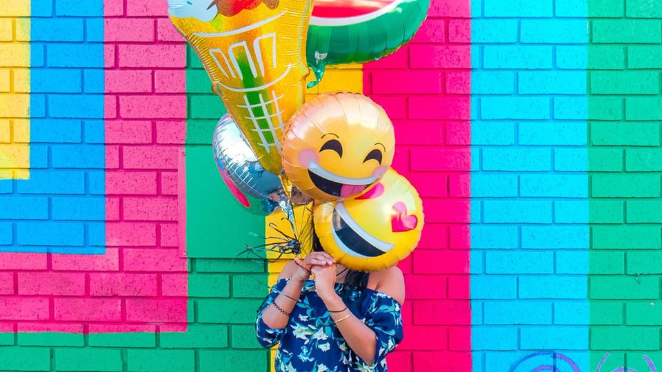 Frau mit Emoji-Ballons