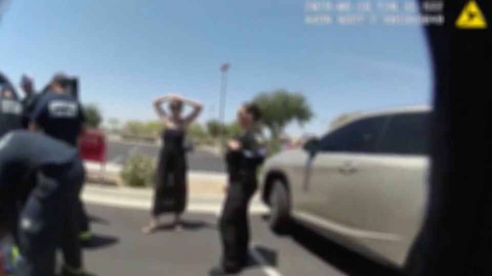 Unscharfes Bild zeigt eine Frau und Polizisten auf einem Parkplatz Unscharfes Bild zeigt eine Frau und Polizisten auf einem Parkplatz