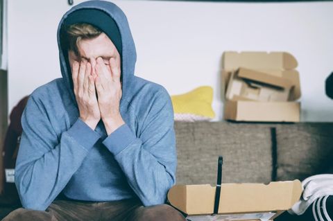 Mann sitzt auf Sofa und ist verzweifelt