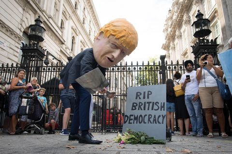 Ein als Boris Johnson verkleideter Demonstrant trägt symbolisch die britische Demokratie zu Grabe