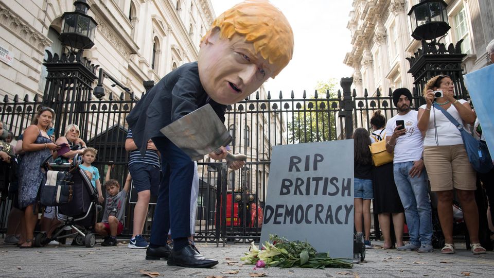 Ein als Boris Johnson verkleideter Demonstrant trägt symbolisch die britische Demokratie zu Grabe