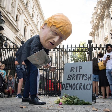 Ein als Boris Johnson verkleideter Demonstrant trägt symbolisch die britische Demokratie zu Grabe