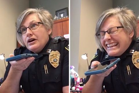Polizistin lacht Telefonbetrüger aus.