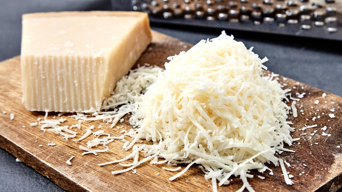 Parmesan im Check: Geriebener Parmesan liegt auf einem Holzbrett