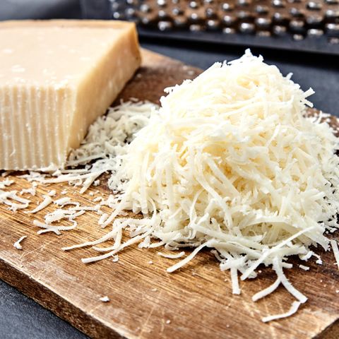 Parmesan im Check: Geriebener Parmesan liegt auf einem Holzbrett