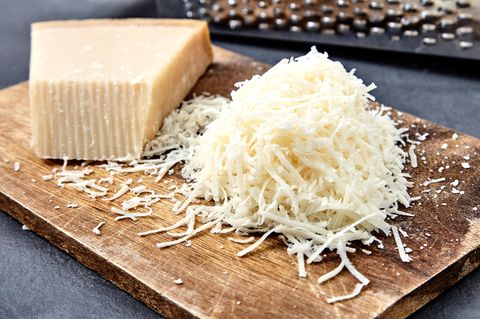 Parmesan im Check: Geriebener Parmesan liegt auf einem Holzbrett