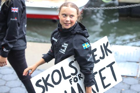 Greta Thunberg trägt ein Schild, auf dem der Schriftzug "Schulstreik für das Klima" steht