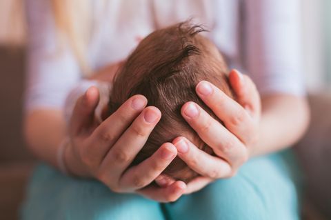 Eine Frau hält ein Baby in den Händen