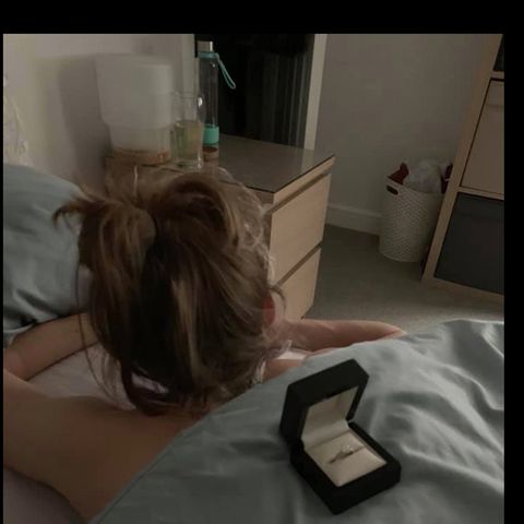 Cally liegt im Bett und merkt nicht, dass eine Ring-Schatulle auf ihrem Rücken liegt