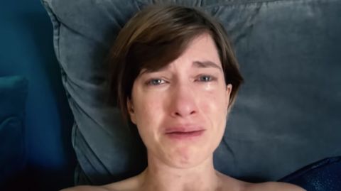 Die Schauspielerin Isabell Horn weint im Bett liegend