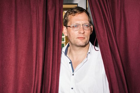 Erfolgsautor Clemens Meyer umrahmt von einem roten Vorhang