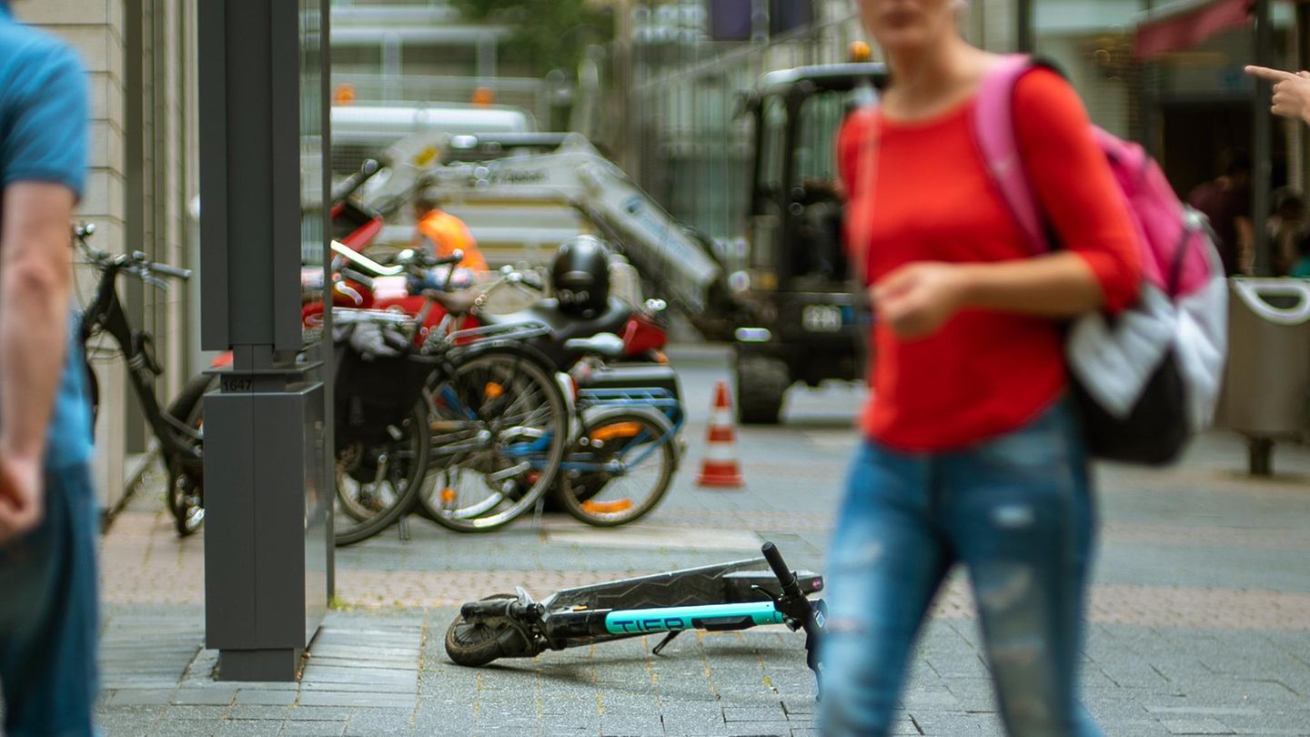 Ein E-Roller liegt mitten auf dem Gehweg
