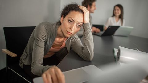 Eine gestresste Frau vor einem Laptop